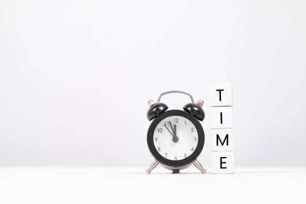 istock A classic alarm clock beside blocks spelling out 'TIME', representing the concept of time management and organization. 2197987248