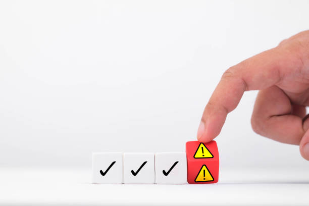 istock A hand presses a warning block among marked checkboxes, symbolizing caution and evaluation in decision making. 2197987278
