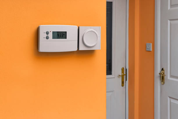 istock White Digital Thermostat with Display for Home Temperature Control and Energy Efficiency for Cost Savings on Orange Wall 2197989114