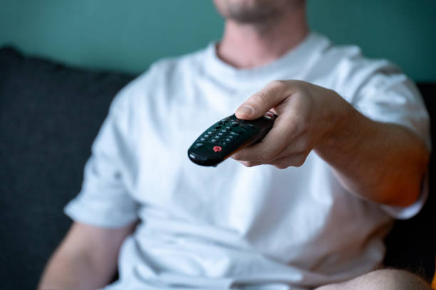 istock close up of television remote control in casual man hands 2197989521