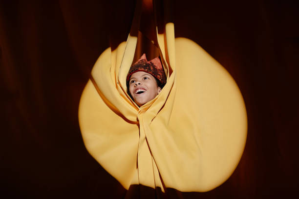 istock Smiling Woman Emerging from Yellow Fabric Cocoon 2197989636