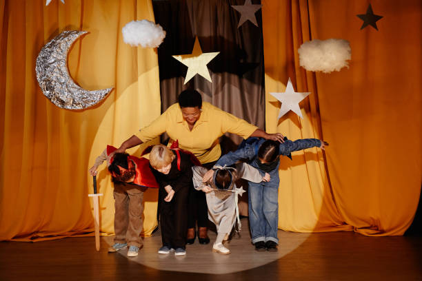 istock Children Performing On Stage with Teacher Guiding 2197989721
