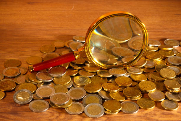 Euro coins under the golden magnifying glass