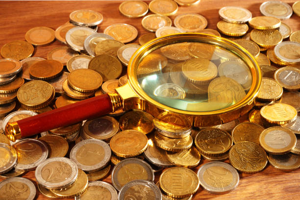 istock Euro coins under the golden magnifying glass 2197992748