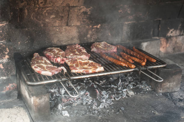 istock Grilling marinated steaks and sausages over open fire in a rustic setting on a summer evening 2197996220