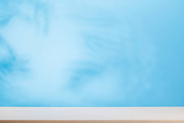 istock Template with empty table and wall with natural plant shadow and sunny glare 2197997916