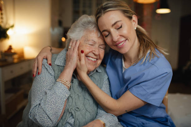 istock Caring healthcare worker visiting a senior patient at home, hugging her. 2197998970