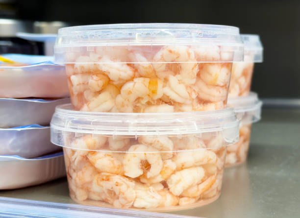 istock Fresh peeled shrimp in plastic containers stacked in refrigerator display 2197998988