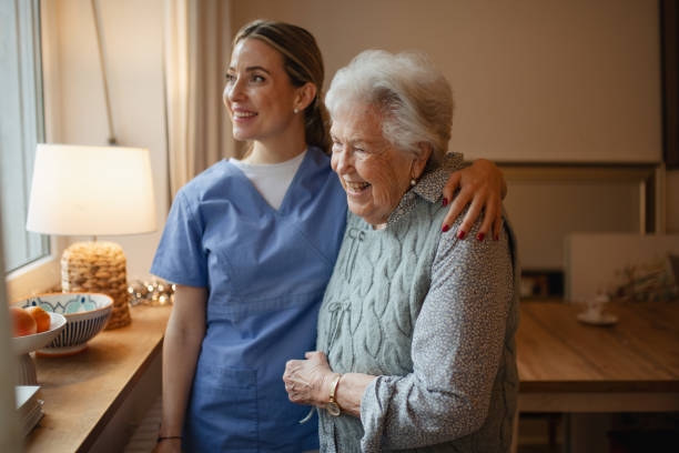 istock Caring healthcare worker visiting a senior patient at home, hugging her. 2197999910