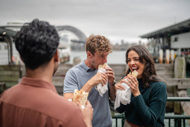istock Young adults enjoying tasty snacks at Sydney waterfront on a cloudy weekend day 2197999913