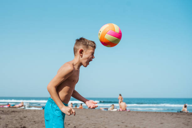 istock Young boy playing soccer on sandy beach, enjoying family vacation. 2198000184