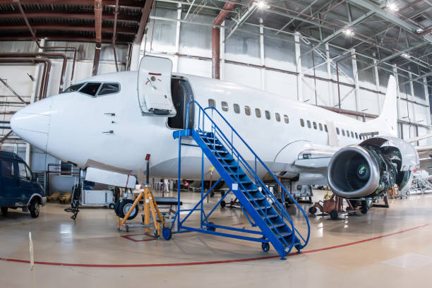 istock White passenger airplane in the aircraft hangar. Airliner under maintenance 2198001675