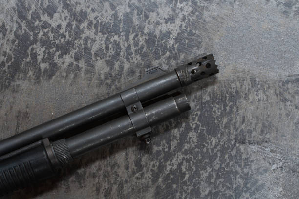 istock Shotgun barrel with flash hider on concrete floor. 2198003950