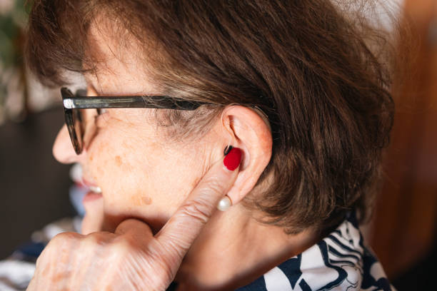 istock Senior woman adjusting hearing aid for better communication and active lifestyle 2198005358