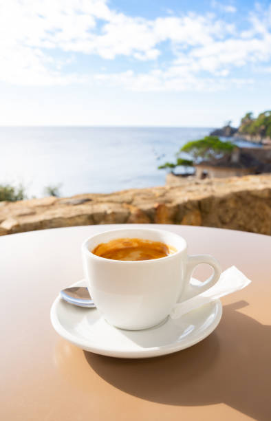 istock Steaming coffee resting near panoramic ocean window, highlighting calm morning moments with soft sunlight filtering through glass 2198005625