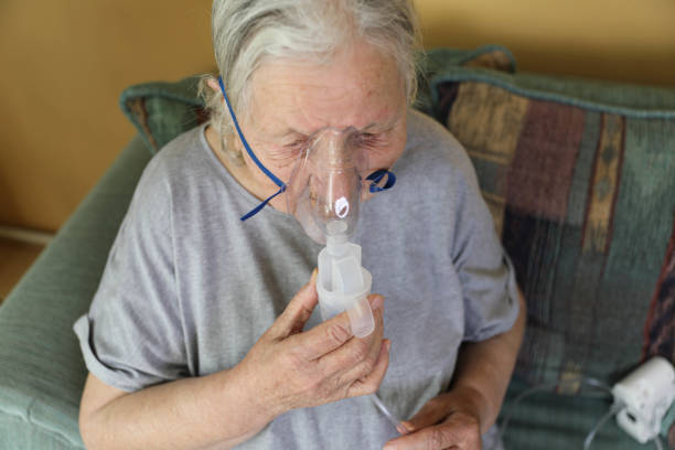 istock A woman with an oxygen mask receiving help from a family member. 2198006263