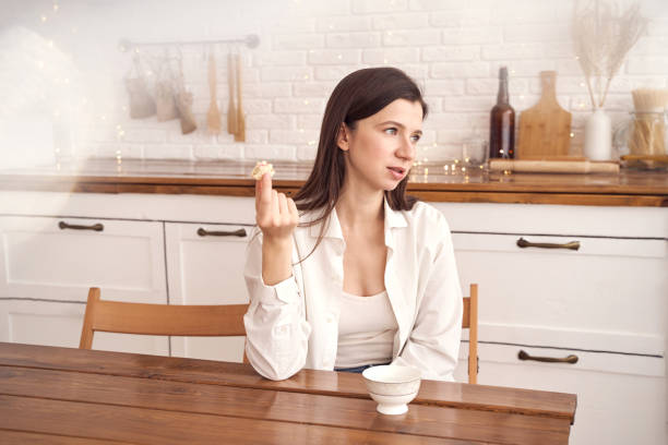 istock Contemplative woman enjoying breakfast in minimalist kitchen with calm 2198007399