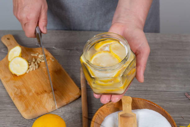 istock woman's hands canning lemon. pour sugar into  jar of lemon. 2198007796