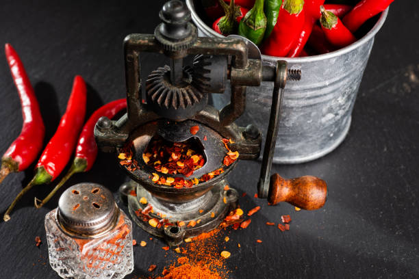 istock mill and finely ground red hot pepper, pepper pods on a black table. 2198007832