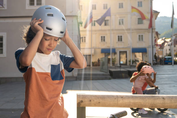 istock Mixed Race Boy Adjusting Helmet for Safety 2198008349