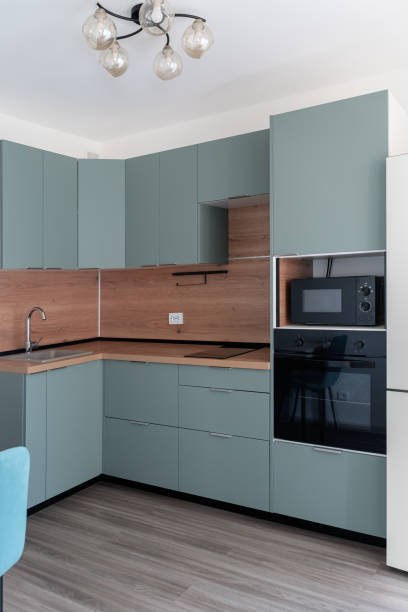istock Modern kitchen with sleek design featuring cabinets, appliances, stylish decor for contemporary home aesthetics. kitchen with green cabinets and wooden backsplash. wooden countertops in kitchen corner 2198008875