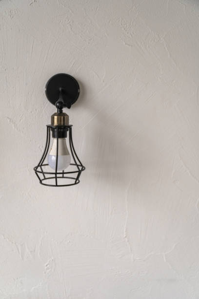 istock Tiny appartment interior. Stylish wall light fixture illuminated against a minimalist white background 2198008943