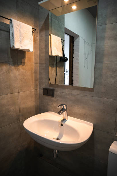 istock Tiny appartment interior. Modern bathroom featuring a wall-mounted sink and stylish mirror 2198009018