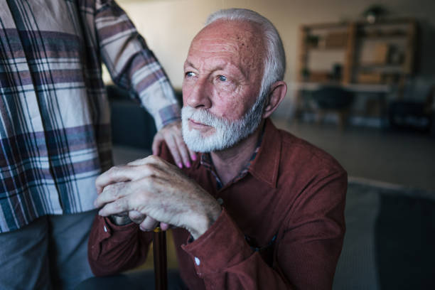 istock Unhappy elderly man sitting on the bed 2198010474