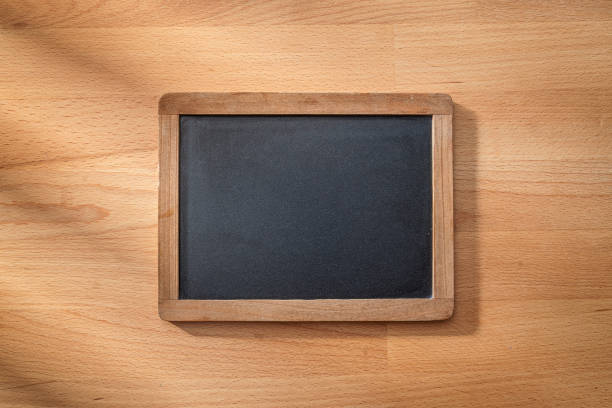 Overhead view of a blank chalkboard on wood surface. Copy space. High resolution 42Mp studio digital capture taken with SONY A7rII and Zeiss Batis 40mm F2.0 CF lens