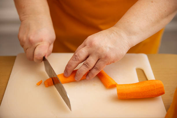 Unknown female hands making pumpkin soup at home