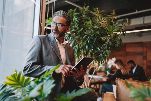 istock Businessman holding digital tablet in sustainable office 2198014990