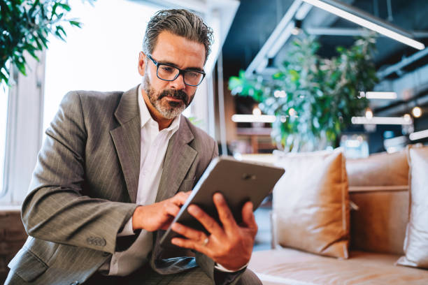 istock Portrait of a businessman holding digital tablet while sitting 2198014991