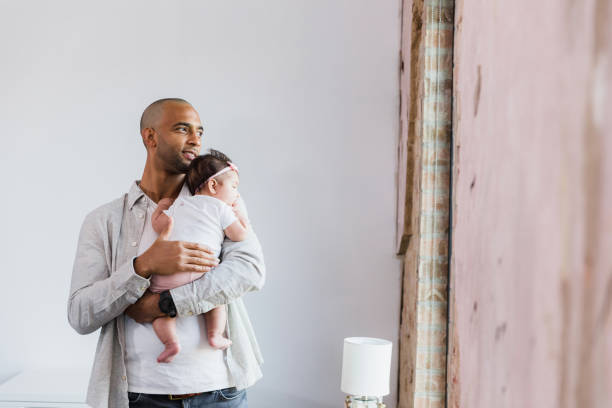istock Tender Moments: Father Gently Holding His Infant Daughter 2198015189