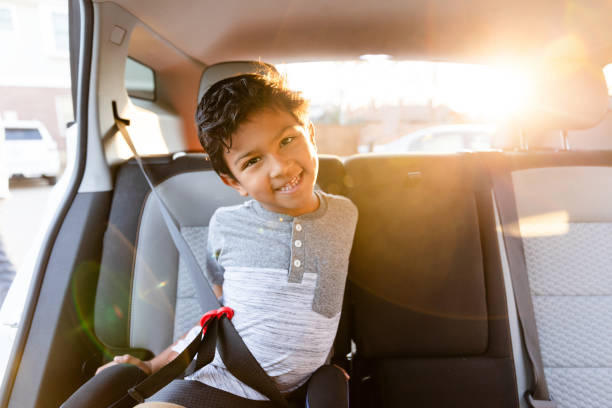 istock Happy Child Smiling in Car Seat, Backlit by Sunset 2198015238