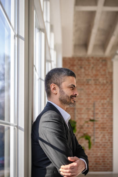 istock Professional man enjoying a moment indoors near large windows in a modern space 2198016325