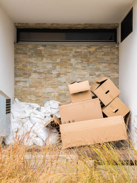 istock Discarded cardboard boxes and white trash bags are ready for recycling outside a building. 2198018893