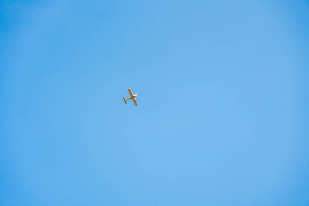 istock Minimalistic view of a small airplane flying against a bright blue sky, emphasizing open space 2198019621