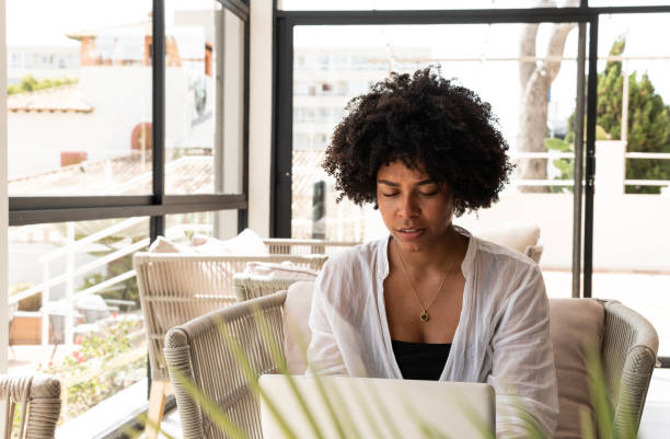 istock Focused young woman working on laptop in a bright, modern office 2198020617