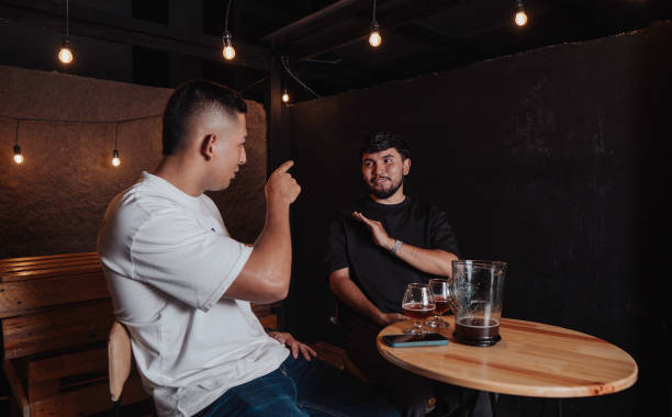 istock friends talking and laughing at a bar table with beer at night 2198024107