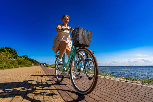 istock Two beautiful mature women riding   bikes on seafront 2198024384
