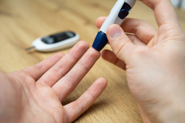 istock Close-up Of A Man's Hand Checking Blood Sugar Level With Glucometer 2198025419