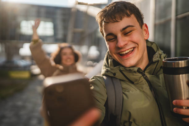 istock man take a self portrait on cellphone with his girlfriend behind him 2198025961