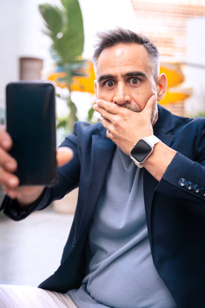 istock Shocked Businessman Looking at Smartphone Screen Outdoors.Vertical 2198030155