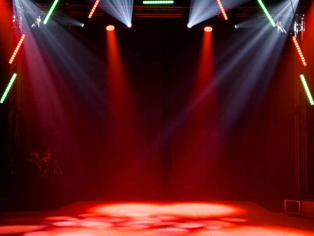 istock Colorful stage lighting with red and white spotlights in dark room 2198030621