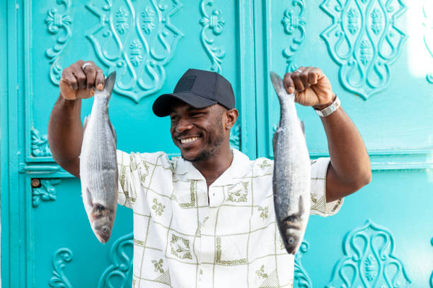 Portrait of afro men holding fish