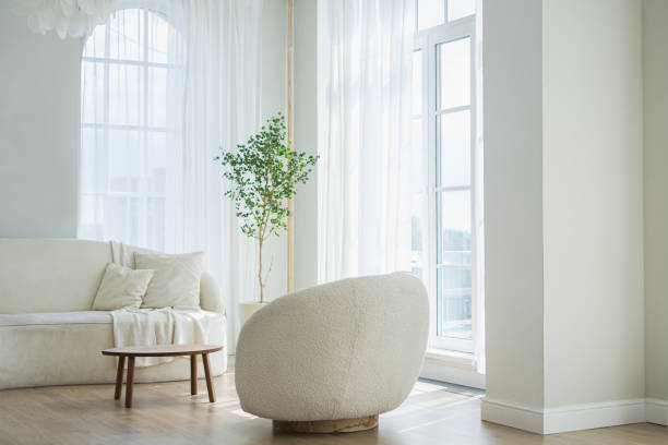 istock Stylish loft bedroom interior. Spacious design apartment with light walls large windows white couch sofa and armchair. Clean modern decoration with elegant furniture in minimalist Scandinavian style. 2198031825