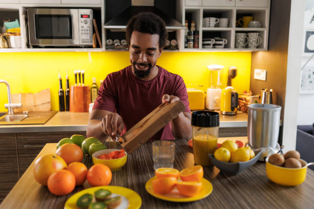 istock Man preparing fresh fruit juice in a kitchen filled with colorful produce 2198033245