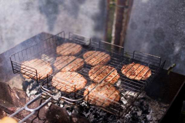 Cooking burgers on hot grill with flames