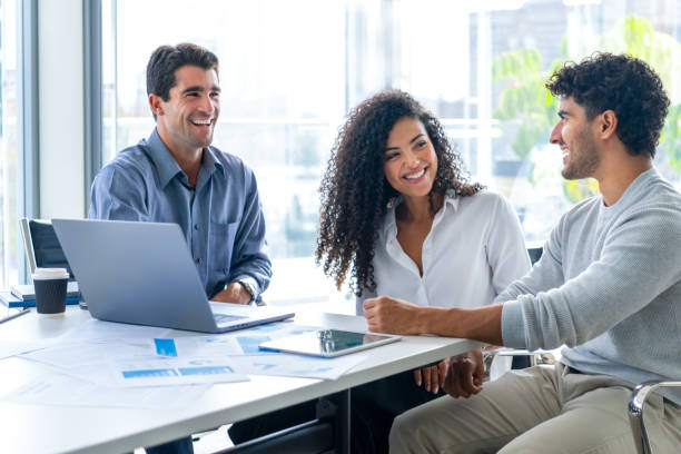 istock Three business people working in the office with technology.. 2198046689