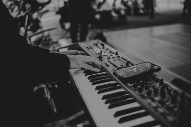 istock Man playing keyboard piano with lyrics on his smart phone 2198051339